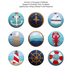 May include: Nine painted round blue and white ceramic tiles with nautical themes. The tiles feature an anchor, compass, sailboat, seagull, porthole view, lobster, lighthouse, ship's wheel, and life preserver.