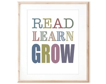Könnte beinhalten: Ein gerahmter Druck mit dem Text "READ LEARN GROW" in bunten, stilisierten Buchstaben. Die Buchstaben sind in Blautönen, Grün, Rot und Lila.