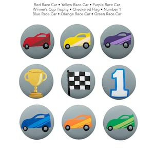 Op de afbeelding: Negen ronde, grijs geverfde houten schijven met verschillende afbeeldingen met een race-thema. De afbeeldingen omvatten een rode raceauto, een gele raceauto, een paarse raceauto, een gouden trofee, een geblokte vlag, het nummer 1, een blauwe raceauto, een oranje raceauto en een groene raceauto.