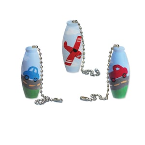 May include: Three wooden fan pull chains with different designs. One has a red airplane, one has a blue car, and one has a red truck.