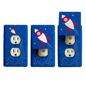 Peut inclure: Trois caches-prises bleus et blancs avec un motif de fusée. Les caches-prises sont décorés d'étoiles et d'une fusée avec des accents rouge, blanc et bleu. Les caches-prises sont une façon amusante et fantaisiste d'ajouter une touche de personnalité à n'importe quelle pièce.