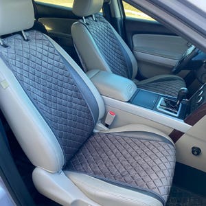 以下が含まれることがあります： ダイヤモンド柄のグレーとベージュの車のシートカバー。カバーは柔らかく、豪華な生地で作られています。
