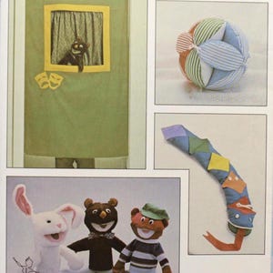 May include: A Kwik Sew pattern featuring various soft toy designs. The image includes a puppet theater, a fabric ball, a segmented snake, and three animal puppets: a rabbit, a bear, and a monkey. The pattern number is 1217.
