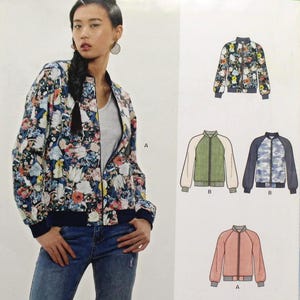 May include: A woman wearing a floral bomber jacket, paired with blue jeans. The jacket is a sewing pattern from New Look, style 6545, with various design options. The pattern includes sizes for a range of measurements.