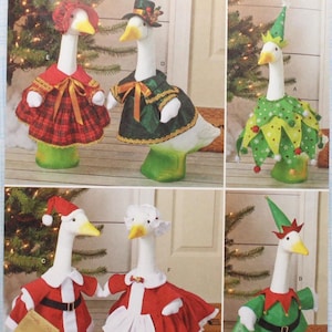 May include: Simplicity pattern S3187 featuring goose figurines in festive Christmas costumes. The geese are dressed as Santa, elves, and in other holiday attire. The pattern is designed and printed in the USA.