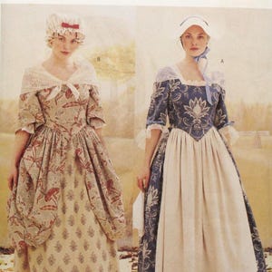 May include: Butterick sewing pattern 3071 for sizes 12, 14, and 16. The envelope features two historical dress designs: one in a beige floral print with a matching cap, and another in a blue and white damask print with a white bonnet.