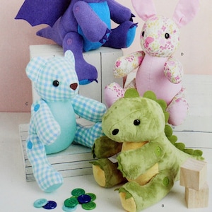 May include: Simplicity sewing pattern S9441 for making four plush toys: a purple dragon, a pink bunny, a blue and white checkered teddy bear, and a green dinosaur. The pattern is for one size.