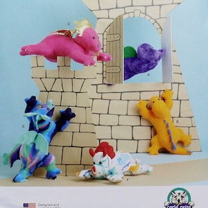 May include: A Simplicity sewing pattern for making five plush dragon toys. The pattern includes a pink dragon, a purple dragon, a yellow dragon, a blue dragon, and a white dragon with red accents. The pattern is for one size and is designed and printed in the USA.