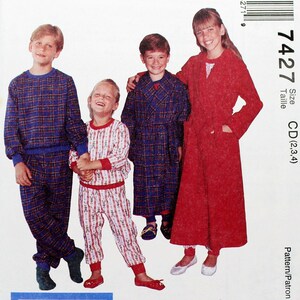May include: A McCall's sewing pattern for children's pajamas. The pattern shows three children wearing pajamas in red, blue, and white plaid. The pattern number is 7427 and the size is CD (2, 3, 4).