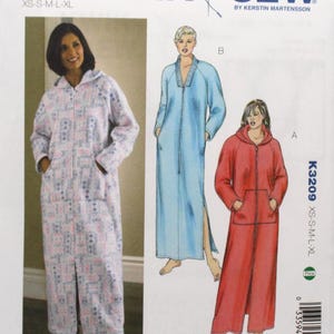 May include: Kwik Sew sewing pattern K3209 for Misses' robes. The pattern features a full-length robe with a hood and zipper closure. The image shows a woman wearing a patterned robe, and illustrations of blue and red robes. The pattern size range is XS-XL.