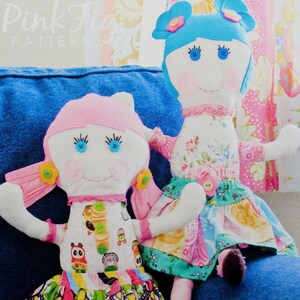 May include: A pattern for making two rag dolls, Roxy and Lola. The dolls are dressed in colorful fabrics with floral and geometric patterns. The pattern is titled "Roxy & Lola Ragdolls" and is numbered "No. 29".