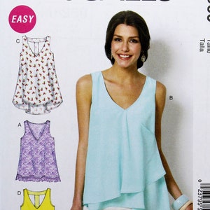 May include: McCall's sewing pattern M6960 featuring a woman wearing a light blue top. The pattern includes illustrations of various top designs, including a floral print, lace, and a yellow tie-front style. The pattern is labeled "EASY".