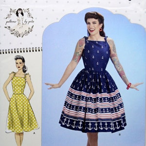May include: Simplicity sewing pattern S8873 featuring a vintage-style dress with anchor and striped designs. The pattern includes sizes 4-12. The image shows a woman wearing the dress, with a drawing of a yellow polka dot dress. Since 1927.