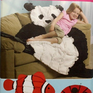 May include: Simplicity fleece throws pattern. The pattern features a panda bear, a clownfish, and a ladybug. The panda bear throw is black and white. The clownfish is red, white, and black. The ladybug is red and black. The pattern is one size.