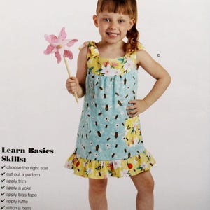 May include: A Simplicity sewing pattern for a girl's dress. The pattern is for sizes 3-6 and includes instructions for making a dress with a yoke, ruffle, and bias tape. The pattern also includes a photo of a girl wearing the finished dress.