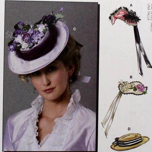 May include: A McCall's pattern envelope featuring a woman wearing a white hat with purple floral accents. The envelope also shows illustrations of other hat designs, including a pink and black feathered hat and a straw hat with a ribbon.