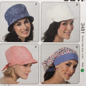 May include: A Kwik Sew pattern for Misses' hats, sizes S-M-L. The pattern features four hat designs: a blue patterned cloche, a white cap with a button detail, a pink hat with a tied back, and a floral print hat with a blue band.