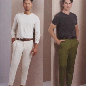 May include: Vogue Patterns V1996 sewing pattern featuring two men modeling different outfits. One wears a white long-sleeve shirt and cream-colored pants. The other wears a dark gray t-shirt and olive green cargo pants. The pattern is designed and printed in the USA.