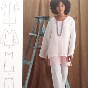 May include: Simplicity sewing pattern S8924 featuring a woman wearing a white tunic, pink top, and white pants. The pattern includes diagrams for a long jacket, top, tank top, and pants. The pattern size is U.S. 8-14.