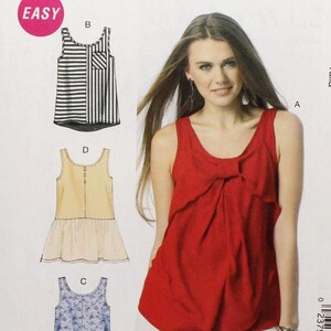 May include: McCall's M6928 sewing pattern featuring a red top with a bow detail, and illustrations of other top designs. The pattern includes sizes X-Small to Medium. The word "EASY" is in a pink circle.
