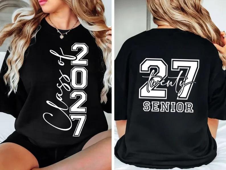 May include: Black t-shirt with white text. The front of the shirt says "Class of 2027" vertically. The back of the shirt says "27 Twenty SENIOR". The shirt is a graduation-themed apparel.
