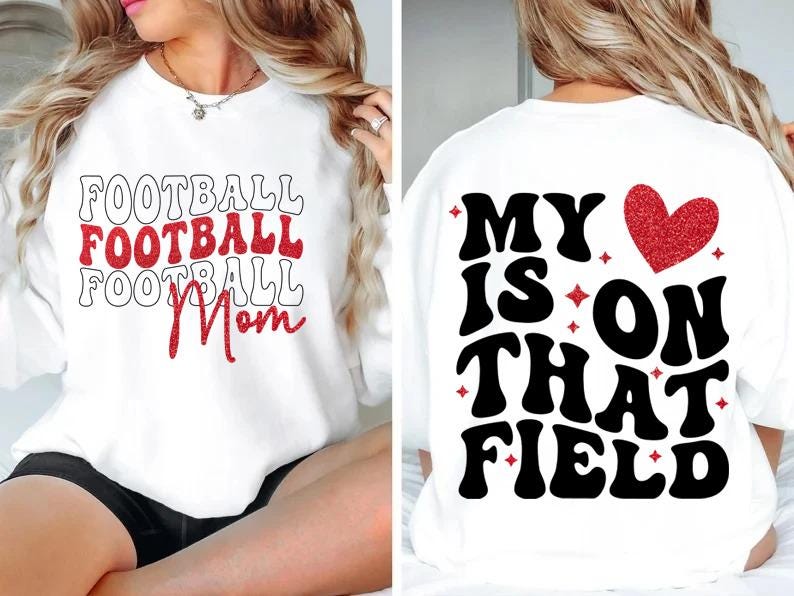 May include: White sweatshirt with the words "FOOTBALL FOOTBALL FOOTBALL Mom" in red and black. The back of the shirt says "MY HEART IS ON THAT FIELD" with a red glitter heart.
