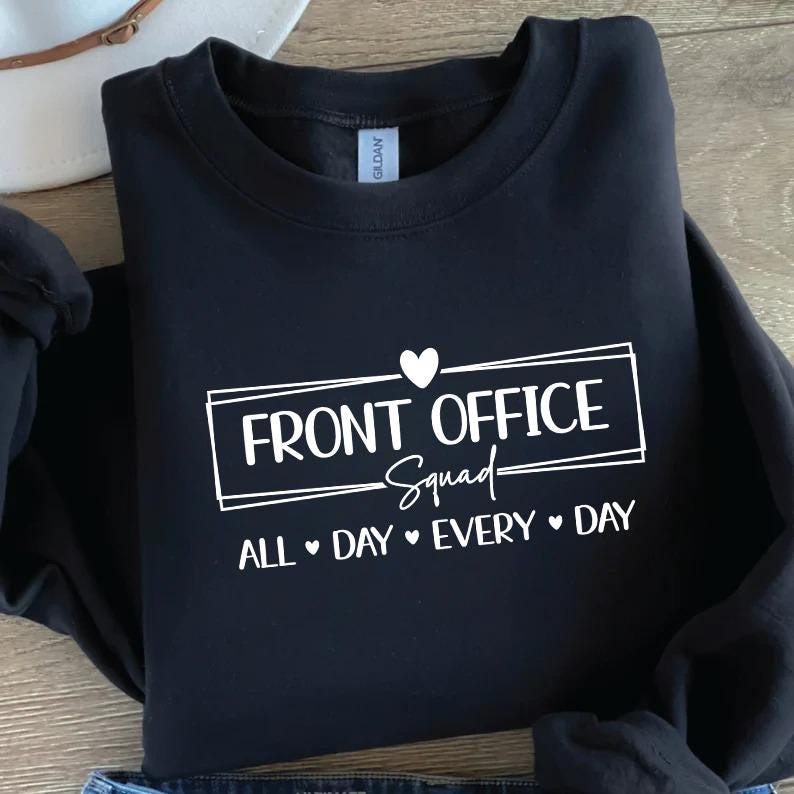 Puede incluir: Sudadera negra con cuello redondo con el texto "FRONT OFFICE Squad" en un rect&aacute;ngulo blanco, con un coraz&oacute;n encima de la palabra "Squad". La frase "ALL DAY EVERY DAY" est&aacute; debajo.