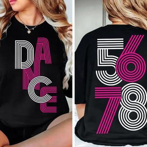 May include: Black t-shirt with the word "DANCE" in white and pink retro font on the front. The back of the shirt features the numbers "5678" in a similar style. A stylish, retro-themed apparel item.