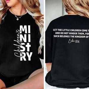 May include: Black long-sleeve shirt with the text "Children's Ministry" in white on the front. The back of the shirt features a quote from Luke 18:16 in white. The shirt is a comfortable, casual style.
