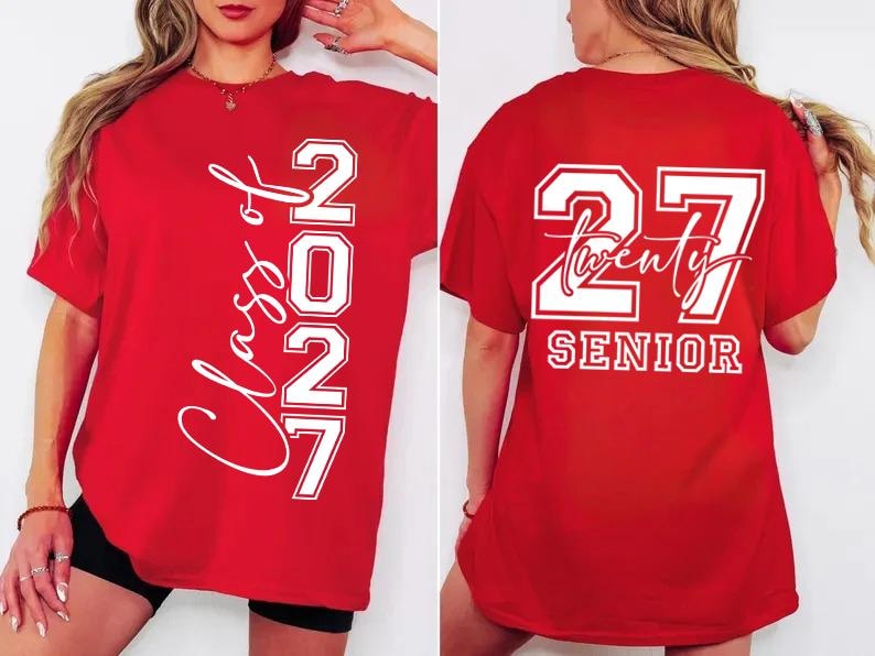 May include: Red t-shirt with white text. The front of the shirt says "Class of 2027" vertically. The back of the shirt says "27 Twenty SENIOR". The shirt is a graduation-themed apparel item.