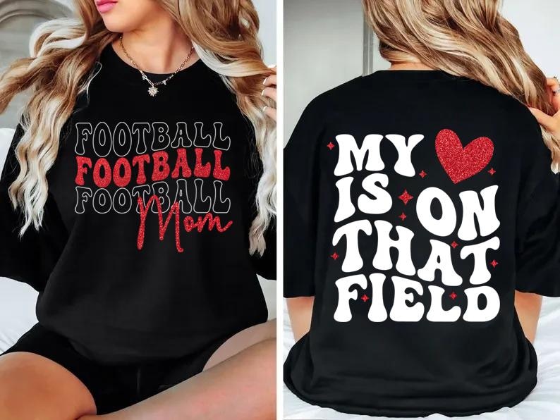 May include: Black t-shirt with the words "FOOTBALL FOOTBALL FOOTBALL Mom" in white and red lettering on the front. The back of the shirt says "MY IS ON THAT FIELD" with a red heart.