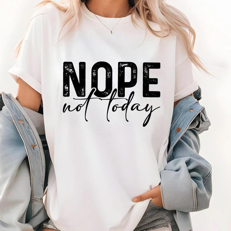 Pode incluir: Camiseta branca com a frase "NOPE not today" em preto. A palavra "NOPE" est&aacute; em negrito, com um estilo desgastado, e "not today" em it&aacute;lico. A camiseta tem mangas curtas.