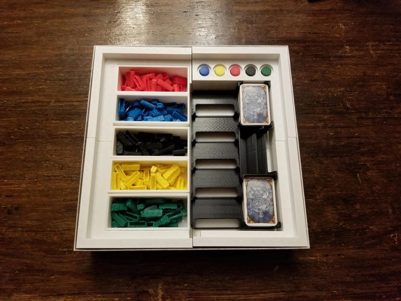 Pu&ograve; includere: Un organizer per giochi bianco con scomparti contenenti pezzi di gioco rossi, blu, neri, gialli e verdi. Ha anche fessure per carte e gettoni colorati. L'organizer &egrave; progettato per mantenere i componenti del gioco ordinati.