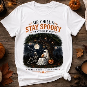 Puede incluir: Una camiseta blanca con un gráfico de un fantasma y un esqueleto sentados bajo un árbol por la noche. El texto dice SIP, CHILL & STAY SPOOKY IT'S MY KIND OF NIGHT y PUMPKIN JUICE & GOOD VIBES. El diseño incluye una luna llena, linternas y una calabaza.
