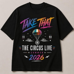 Puede incluir: Una camiseta negra de manga corta con un estampado gráfico colorido. El texto "TAKE THAT" en fuente degradada aparece sobre una ilustración de paracaídas, con "1990", "THE CIRCUS LIVE", "SUMMER" y "2026" en fuente degradada multicolor abajo.