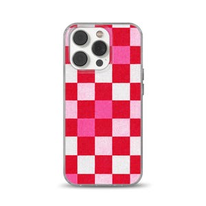 May include: A clear phone case with a red, pink, and white checkerboard pattern. The case has a camera cutout and side buttons. The design is a repeating pattern of squares in varying shades of red, pink, and white.