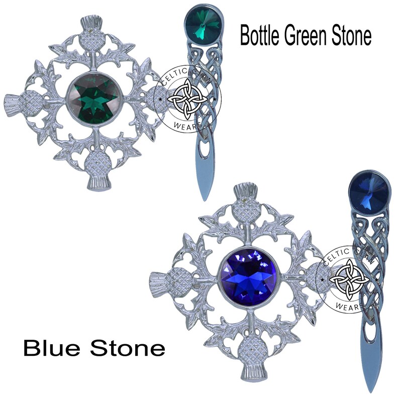 K&ouml;nnte beinhalten: Zwei silberne keltische Knotenbroschen mit Distelmotiven. Eine Brosche hat einen blauen Stein und die andere einen gr&uuml;nen Stein. Der Text "Bottle Green Stone" und "Blue Stone" ist unter den Broschen sichtbar.