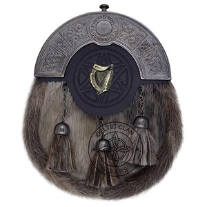 K&ouml;nnte beinhalten: Ein traditioneller schottischer Kilt-Sporran mit einem Fellk&ouml;rper und einem dekorativen Metall-Cantle. Der Sporran hat eine schwarze Lederklappe mit einem goldenen Harfenemblem und dekorativen Quasten. Der Cantle hat keltische Knotenmuster.