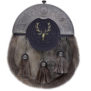 K&ouml;nnte beinhalten: Ein traditioneller schottischer Kilt-Sporran mit einem silberfarbenen Cantle mit keltischen Knoten. Die schwarze Lederklappe hat ein goldfarbenes Hirschkopf-Emblem. Der Sporran hat einen Pelzk&ouml;rper, Quastenketten und ein dekoratives Emblem.