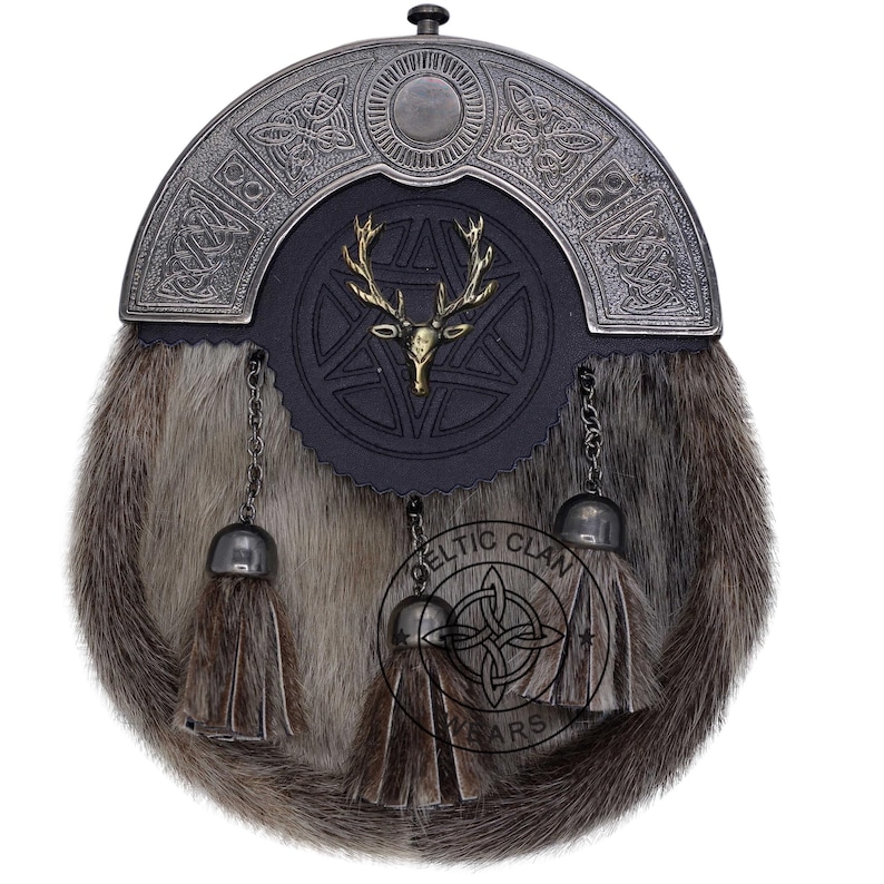 K&ouml;nnte beinhalten: Ein traditioneller schottischer Kilt-Sporran mit einem silberfarbenen Cantle mit keltischen Knoten. Die schwarze Lederklappe hat ein goldfarbenes Hirschkopf-Emblem. Der Sporran hat einen Pelzk&ouml;rper, Quastenketten und ein dekoratives Emblem.