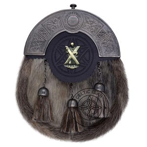 K&ouml;nnte beinhalten: Ein traditioneller schottischer Sporran mit einem Fellk&ouml;rper und einem dekorativen Metallaufsatz. Der Sporran hat eine schwarze Lederklappe mit einem Metallabzeichen und drei h&auml;ngenden Quasten. Das Celtic Clan-Logo ist sichtbar.