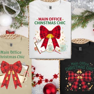 Op de afbeelding: Drie t-shirts met de tekst "Main Office Christmas Chic" en een rood geruit strikdesign. De shirts zijn verkrijgbaar in wit, beige en zwart. Het ontwerp bevat bellen, zuurstokken en mokken.