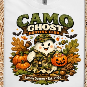 May include: A white t-shirt featuring a graphic of a ghost wearing a camouflage hat and vest, holding a jack-o'-lantern bucket. The text reads CAMO GHOST HUNTING CLUB and Candy Season Est. 2026, surrounded by autumn leaves, pumpkins, and acorns.