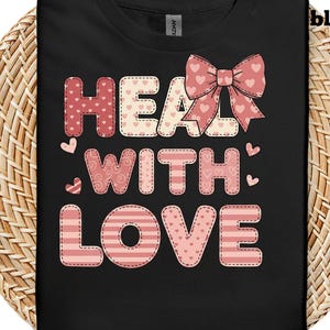 May include: Black t-shirt with the words "HEAL WITH LOVE" in a patchwork style. The letters are in pink and white with heart and bow accents. The word "black" is in the upper right corner.