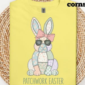 Puede incluir: Camiseta amarilla con un conejito de Pascua de patchwork con gafas de sol y un lazo rosa. El texto "PATCHWORK EASTER" está debajo del conejito. La palabra "cornsilk" está en la parte superior derecha.