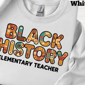 Könnte beinhalten: Weißes Sweatshirt mit dem Schriftzug "BLACK HISTORY ELEMENTARY TEACHER" in bunten, gemusterten Buchstaben. Das Design enthält Bilder von Händen, Büchern und Bleistiften. Das Sweatshirt ist aus einem weichen Material.