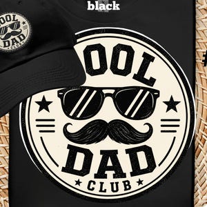 May include: Black baseball cap and t-shirt with a "Cool Dad Club" design. The design features sunglasses, a mustache, and the words "Cool Dad Club" in a circular emblem. The t-shirt also has the number "#2" on the side.