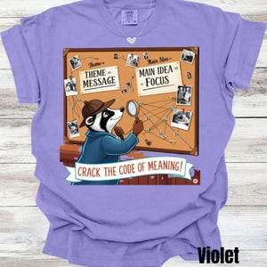 Könnte beinhalten: Violettes T-Shirt mit einer Grafik eines Dachs-Detektivs, der ein Korkbrett mit Fotos untersucht und den Text "CRACK THE CODE OF MEANING!". Das Brett trägt die Worte "Theme = MESSAGE" und "Main Idea = FOCUS".