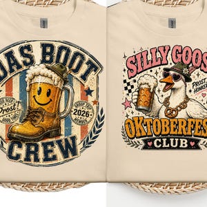 Può includere: Due magliette color crema con stampe grafiche. La maglietta a sinistra mostra un boccale di birra a forma di stivale con una faccina sorridente, il testo "DAS BOOT CREW" e "2026". Quella a destra mostra un'oca con occhiali da sole e cappello, con "SILLY GOOSE OKTOBERFEST CLUB".