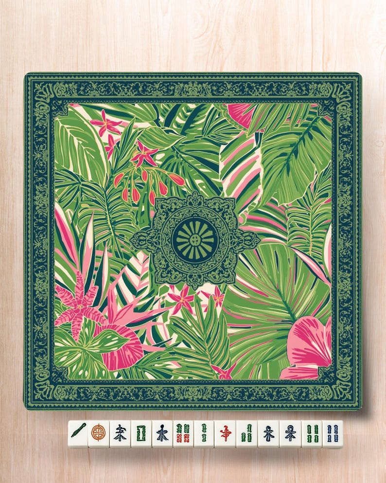 May include: Square decorative mat with a tropical leaf pattern in shades of green, pink, and white. The mat has a dark green border with a floral design. A set of Mahjong tiles are at the bottom.